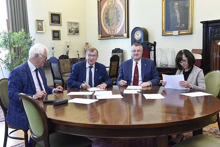 Zdjecie czterech osób siedzących za przy okrągłym stole.