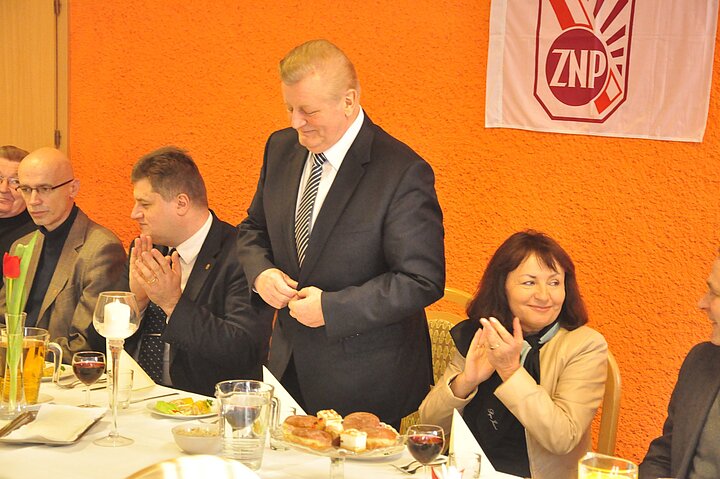 Ludzie przy stole prezydialnym. W tle logotyp ZNP, stoi JM Rektor