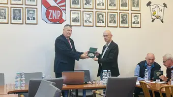 Prezes Sala wręcza odznaczenie dr Andrzejowi Kotowi