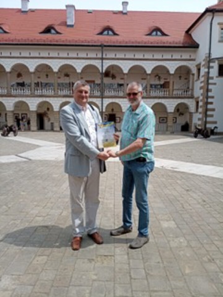 Mężczyźni stoją w grupie na tle Zamku